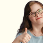 UK Disability History Month - a person with downs syndrome giving the onlooker a thumbs up
