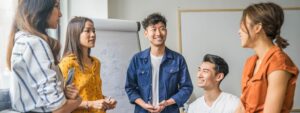 East Asian and South East Asia colleagues standing in a circle having a meeting about their ESEA heritage month plans