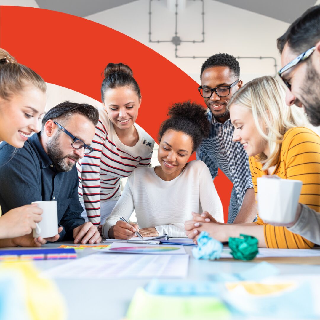 Image shows a large, diverse group of co-workers doing National Inclusion Week prep. The image is intersected with a red arch.